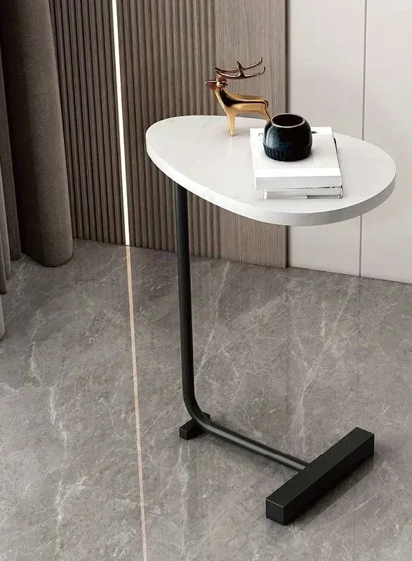Fitlybuy modern side table with a white oval top, black metal frame, and decor, set against a stylish marble floor.