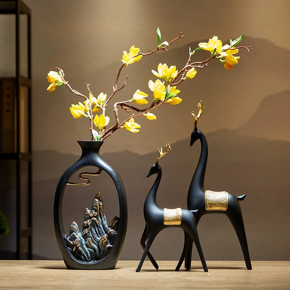 Fitlybuy TranquilPeak black ceramic vase with mountain art, holding yellow flowers beside two elegant black deer statues.