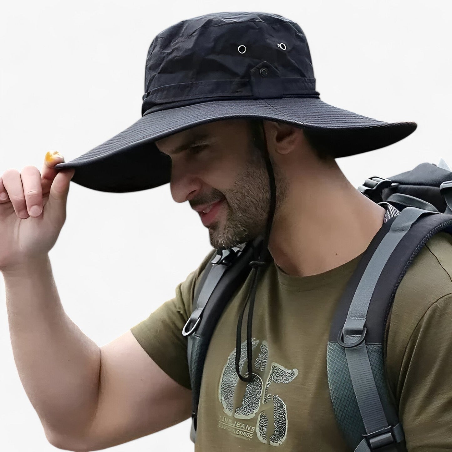 Man wearing a black Fitlybuy Zeno UV protection wide-brim outdoor hiking hat with a chin strap and backpack.