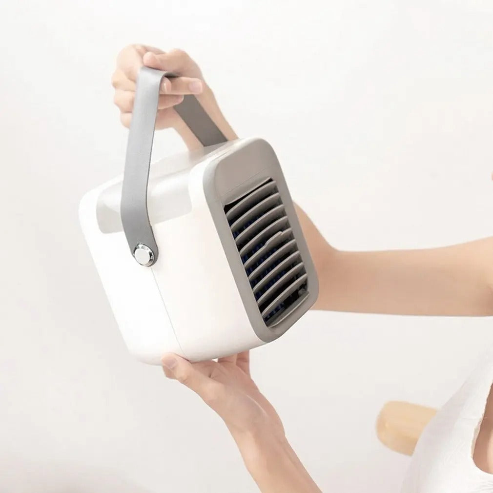 Portable white and gray Fitlybuy 3-in-1 mini air conditioner with a carry handle being held by a person.