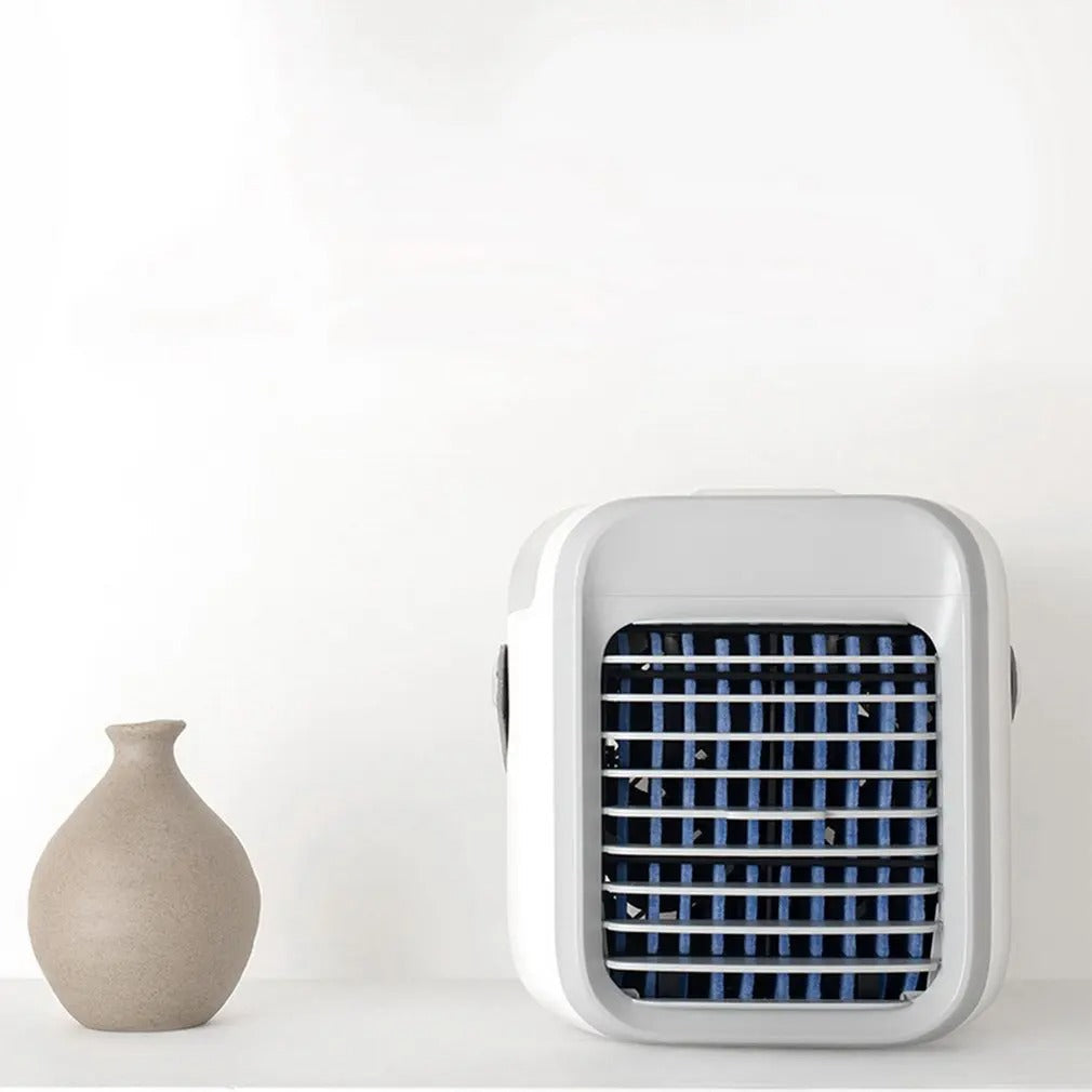 Fitlybuy 3-in-1 white and grey portable mini air conditioner with blue cooling vents on a white shelf near a vase.