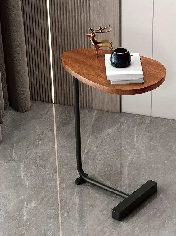 Fitlybuy modern side table with a wood-grain oval top and black metal C-frame, styled with decor on a marble floor.