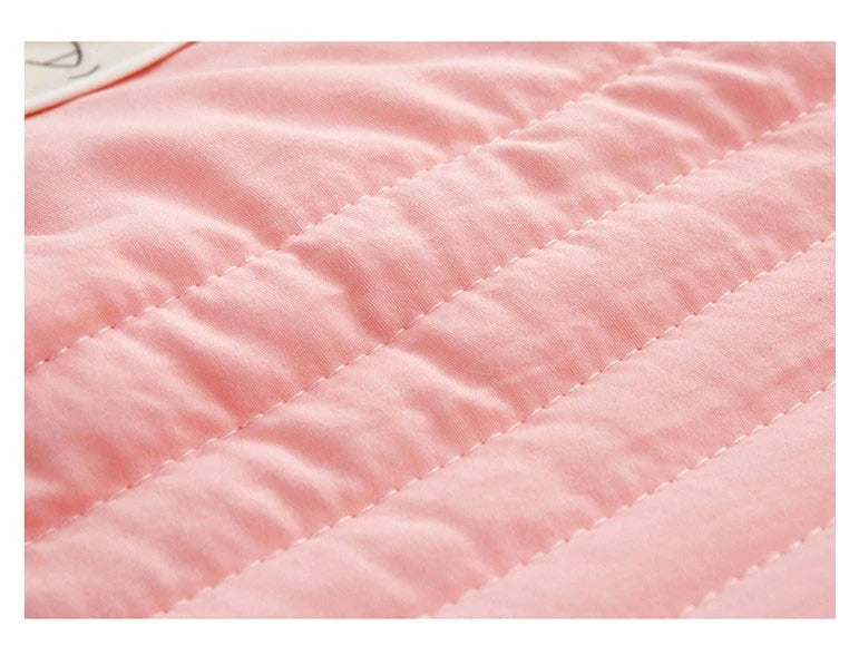 Close-up of a soft pink Fitlybuy premium cooling blanket with ThermoRegulate stitched channels and smooth fabric.