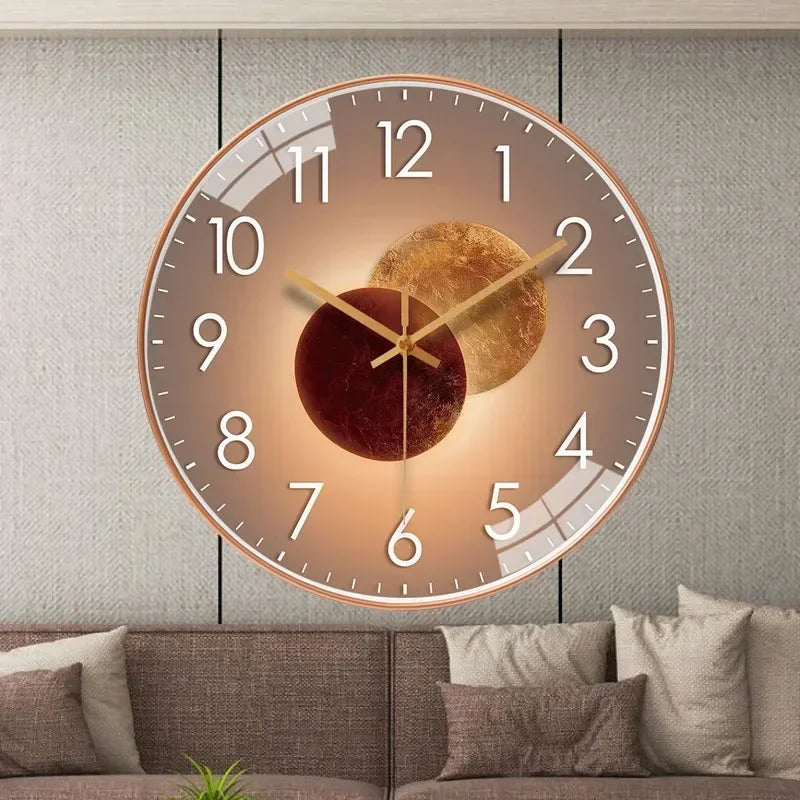 Fitlybuy silent wall clock with a bronze frame, gold-brown planet motif, and white numbers, mounted on a living room wall.