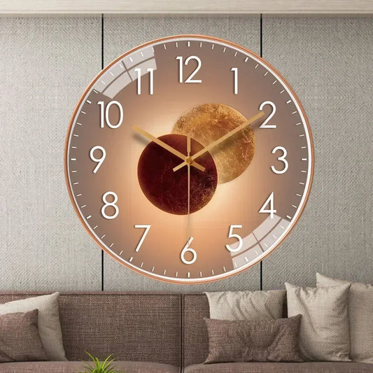 Fitlybuy silent wall clock with a bronze frame, gold-brown planet motif, and white numbers, mounted on a living room wall.