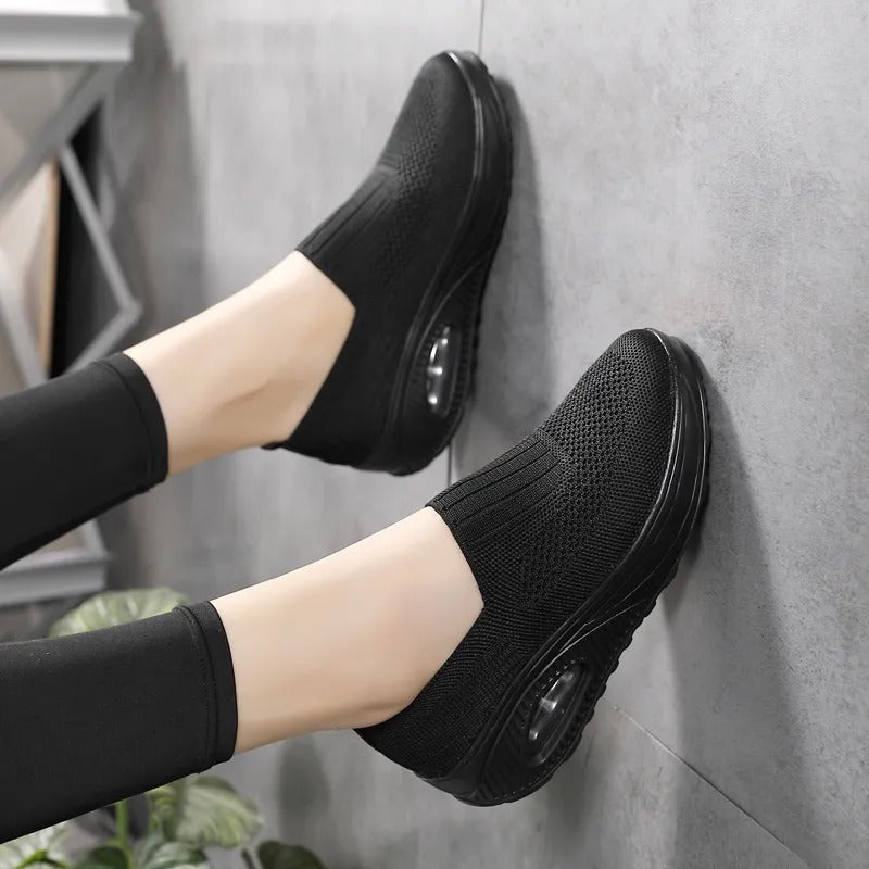 Fitlybuy black orthopedic slip-on sneakers with breathable knit mesh and air-cushion support soles.