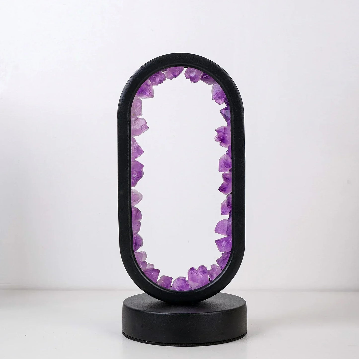 Fitlybuy AuraStone oval lamp with raw purple amethyst crystals set inside a sleek, black circular frame and base.