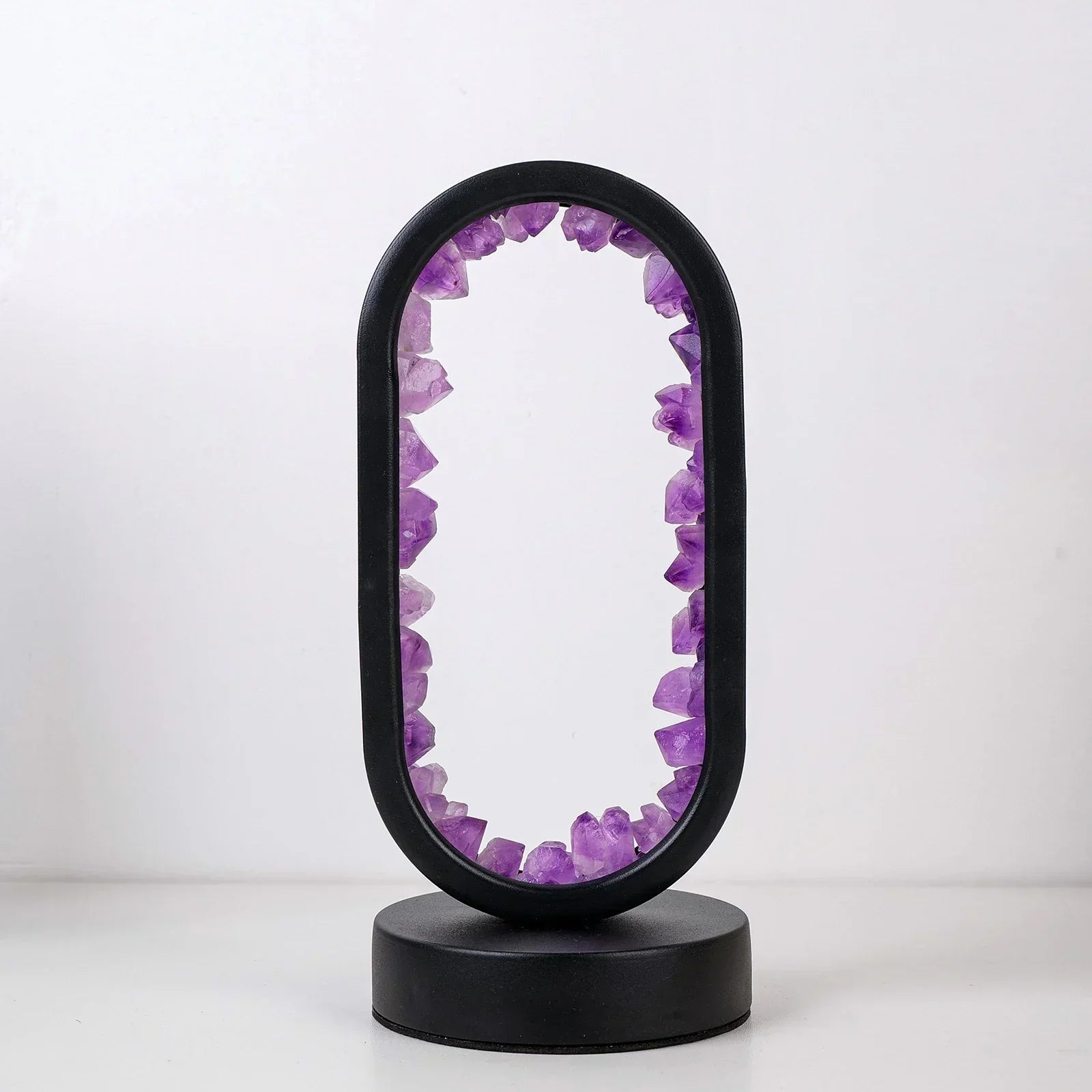 Fitlybuy AuraStone oval lamp with raw purple amethyst crystals set inside a sleek, black circular frame and base.