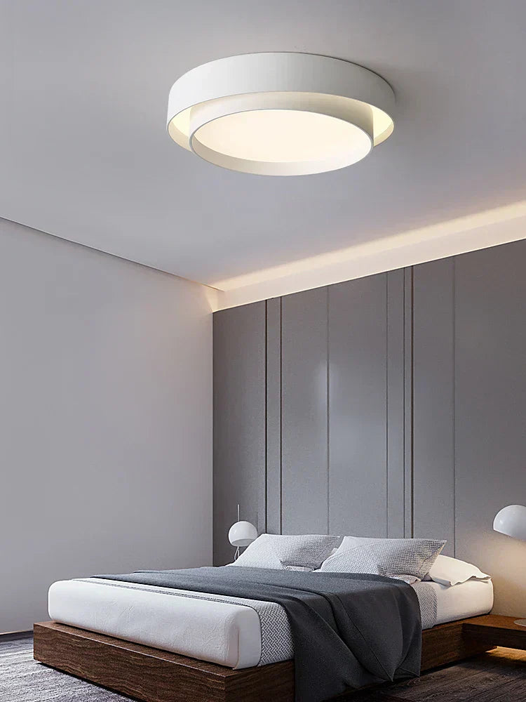 Fitlybuy NordicAura: A white, circular, tiered minimalist LED ceiling light installed in a modern grey bedroom.