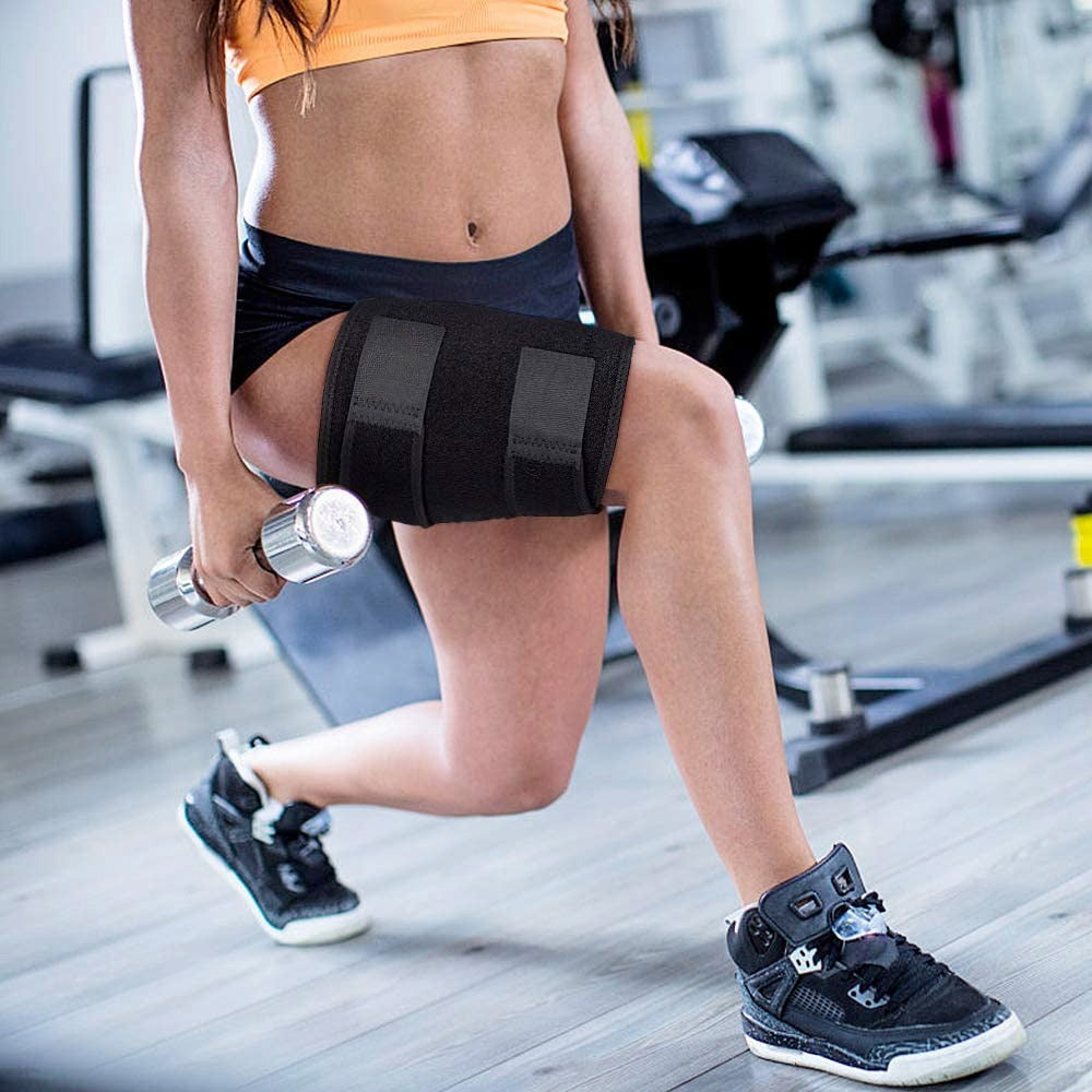 Person doing lunge in gym wearing a black Fitlybuy adjustable compression thigh brace wrap while holding a dumbbell.