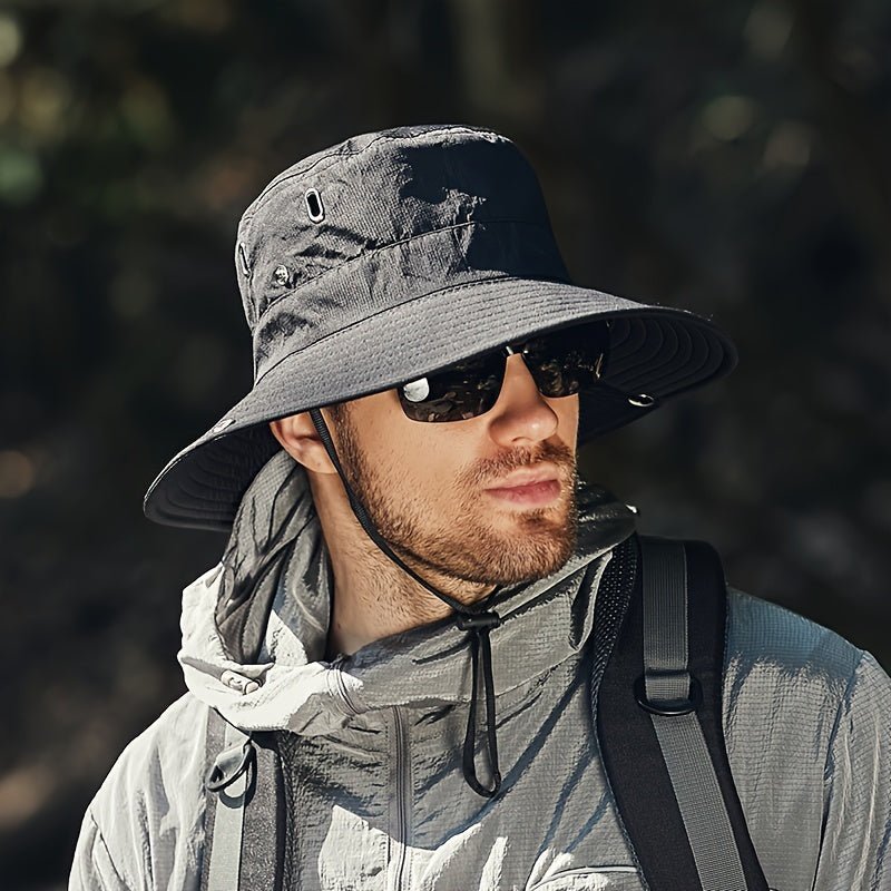 Man wearing a dark gray, wide-brimmed Fitlybuy SUNSAFE breathable UV protection bucket hat with a chin strap.
