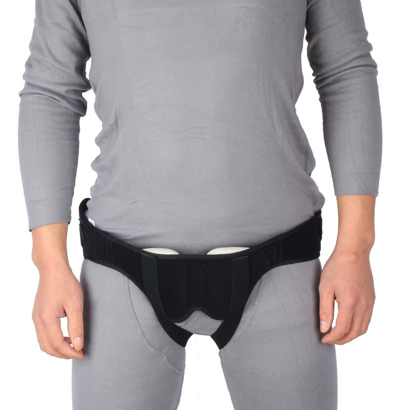 Fitlybuy black hernia support belt with adjustable compression pads worn over grey clothing for groin support.