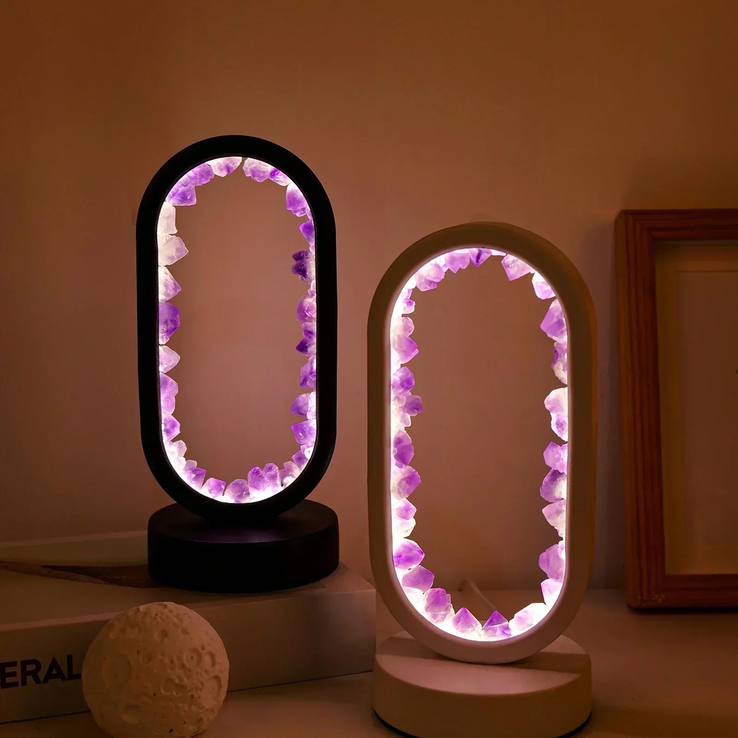 Two oval Fitlybuy AuraStone lamps with glowing purple amethyst crystals inside black and white circular frames.