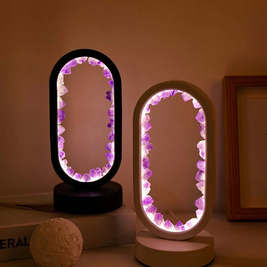 Two oval Fitlybuy AuraStone lamps with glowing purple amethyst crystals inside black and white circular frames.