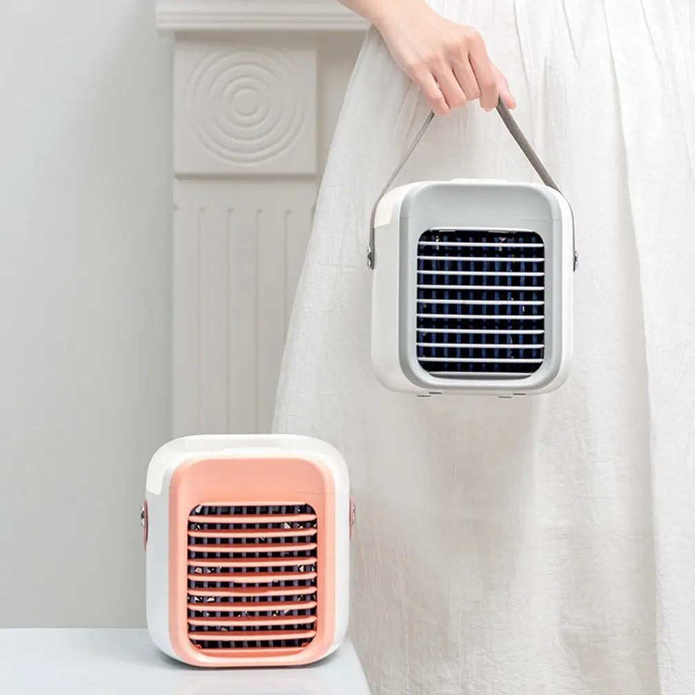 Fitlybuy portable 3-in-1 mini air conditioner with EcoCool tech. Person holding a white unit; pink unit on table.