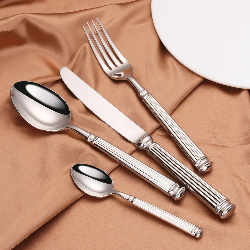 Fitlybuy 304 stainless steel cutlery set with mirror finish and ribbed handles on a gold satin fabric background.