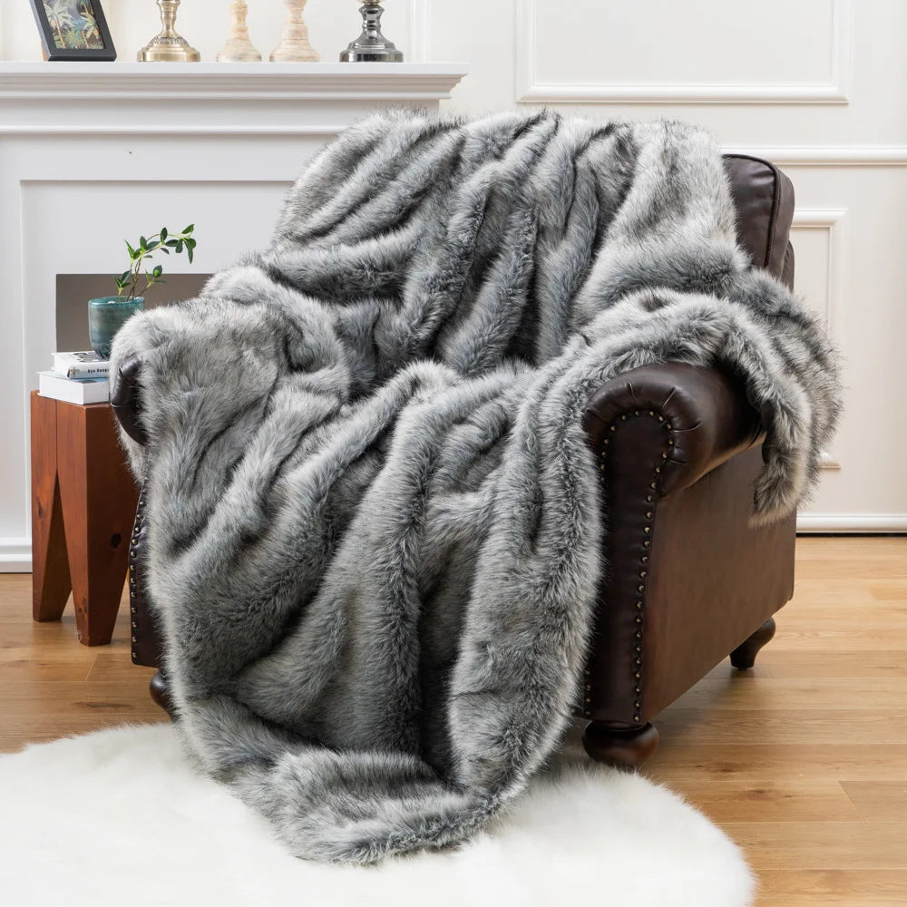 Fitlybuy gray faux fox fur throw blanket draped over a brown leather armchair in a living room.