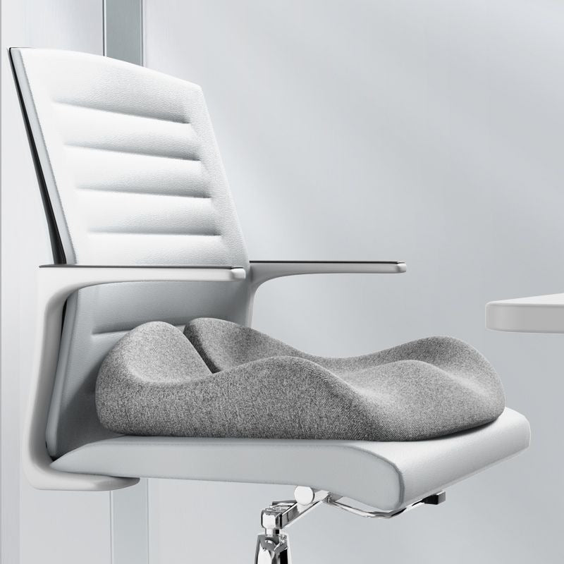 Gray, ergonomically contoured Sciatica relief seat cushion placed on a modern white office chair.