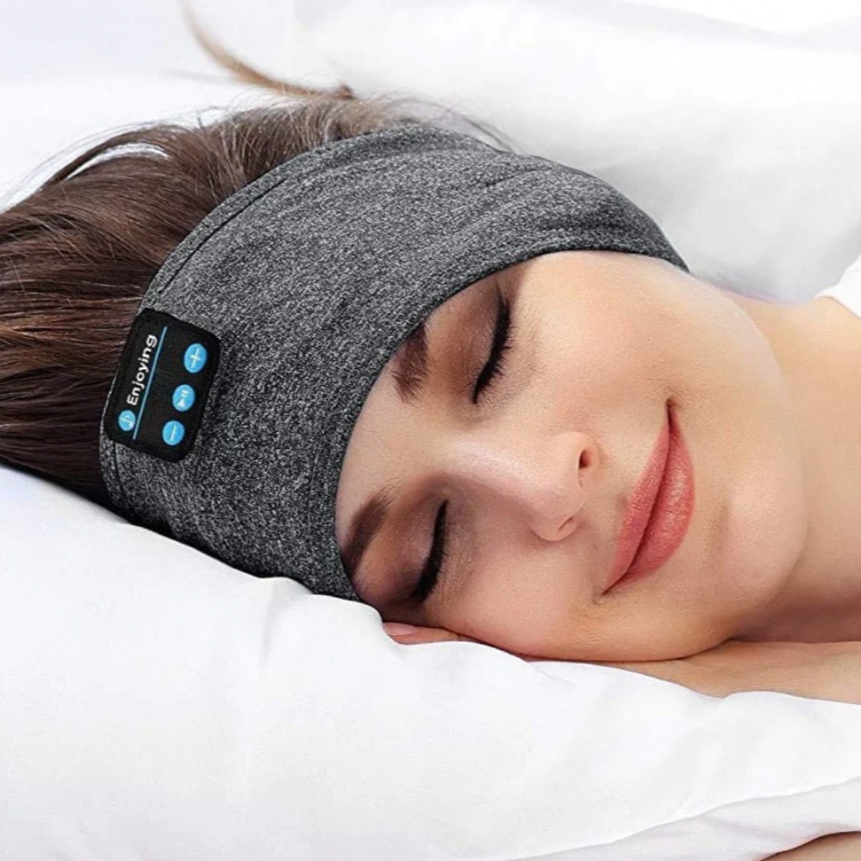 Woman sleeping on white pillow wearing a gray Fitlybuy Bluetooth sports headband with integrated playback controls.