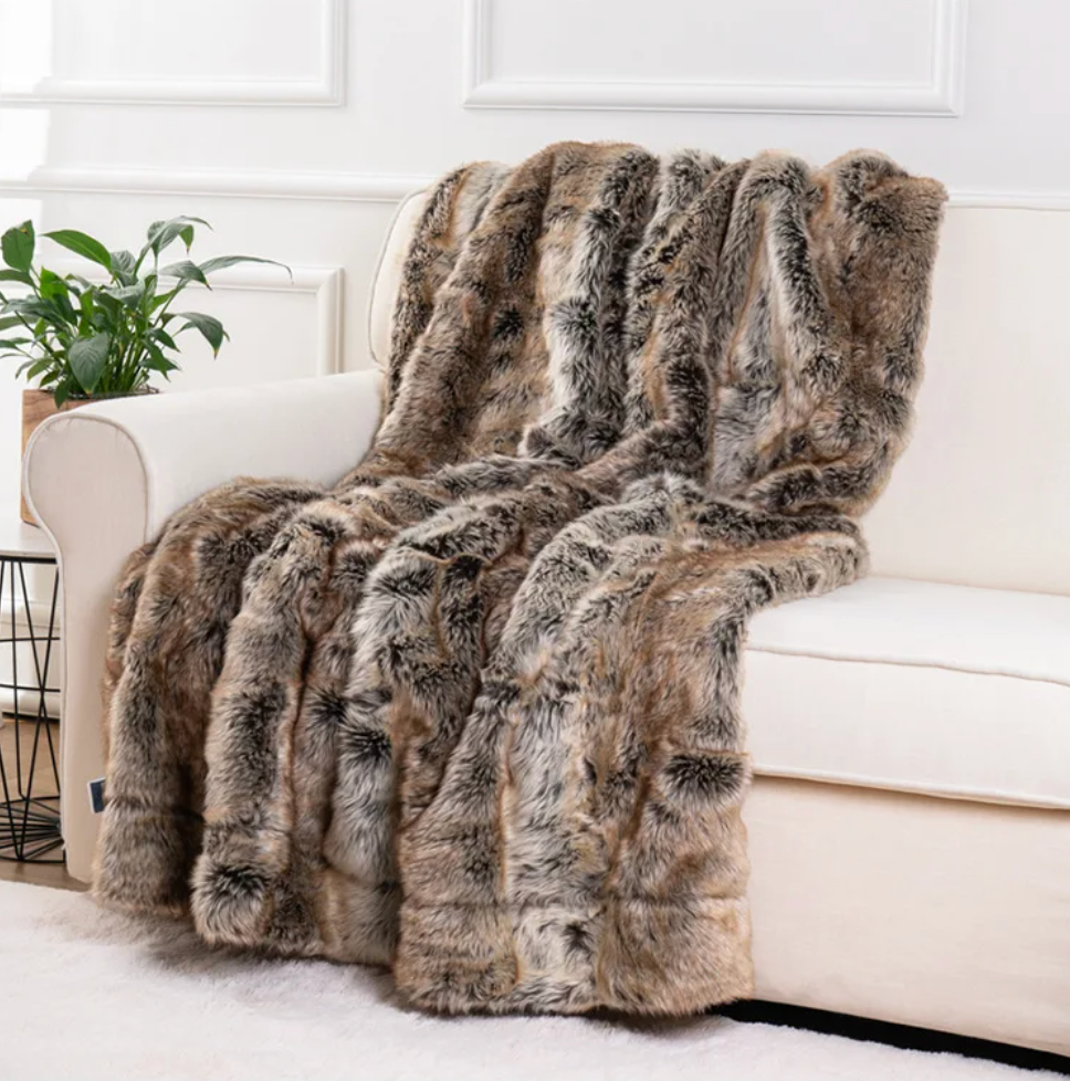 Fitlybuy brown and grey faux mink fur throw blanket draped over a white couch in a living room.
