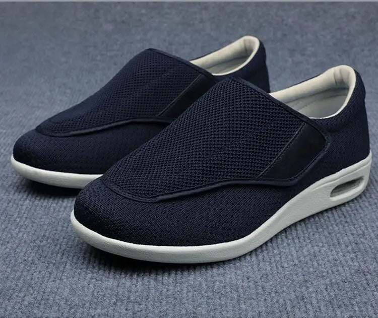 Fitlybuy ComfortStride navy mesh orthopedic walking shoes with white cushioned soles on a grey carpet background.