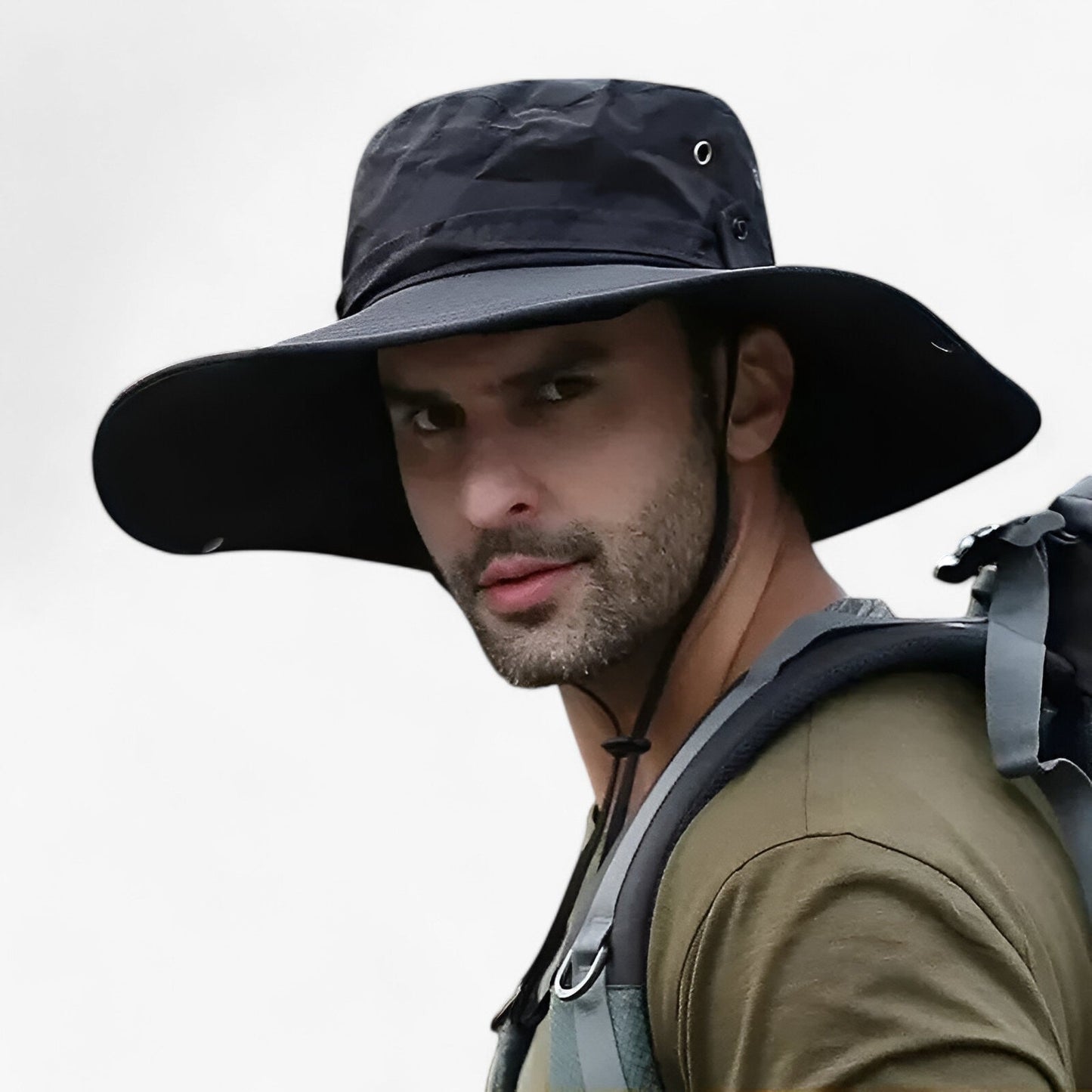 Man wearing a black Fitlybuy Zeno wide-brim UV protection outdoor hat with an adjustable chin strap and backpack.