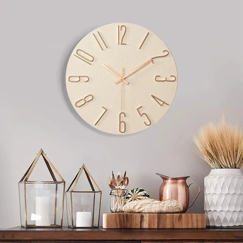 Fitlybuy frameless light wood wall clock with rose gold numbers, mounted on a grey wall above rustic home decor.