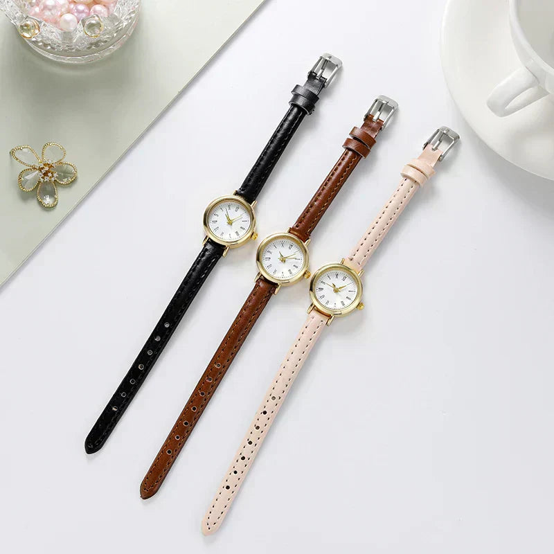 Three Fitlybuy Billie gold-tone round watches with Roman numerals and thin black, brown, and beige leather straps.