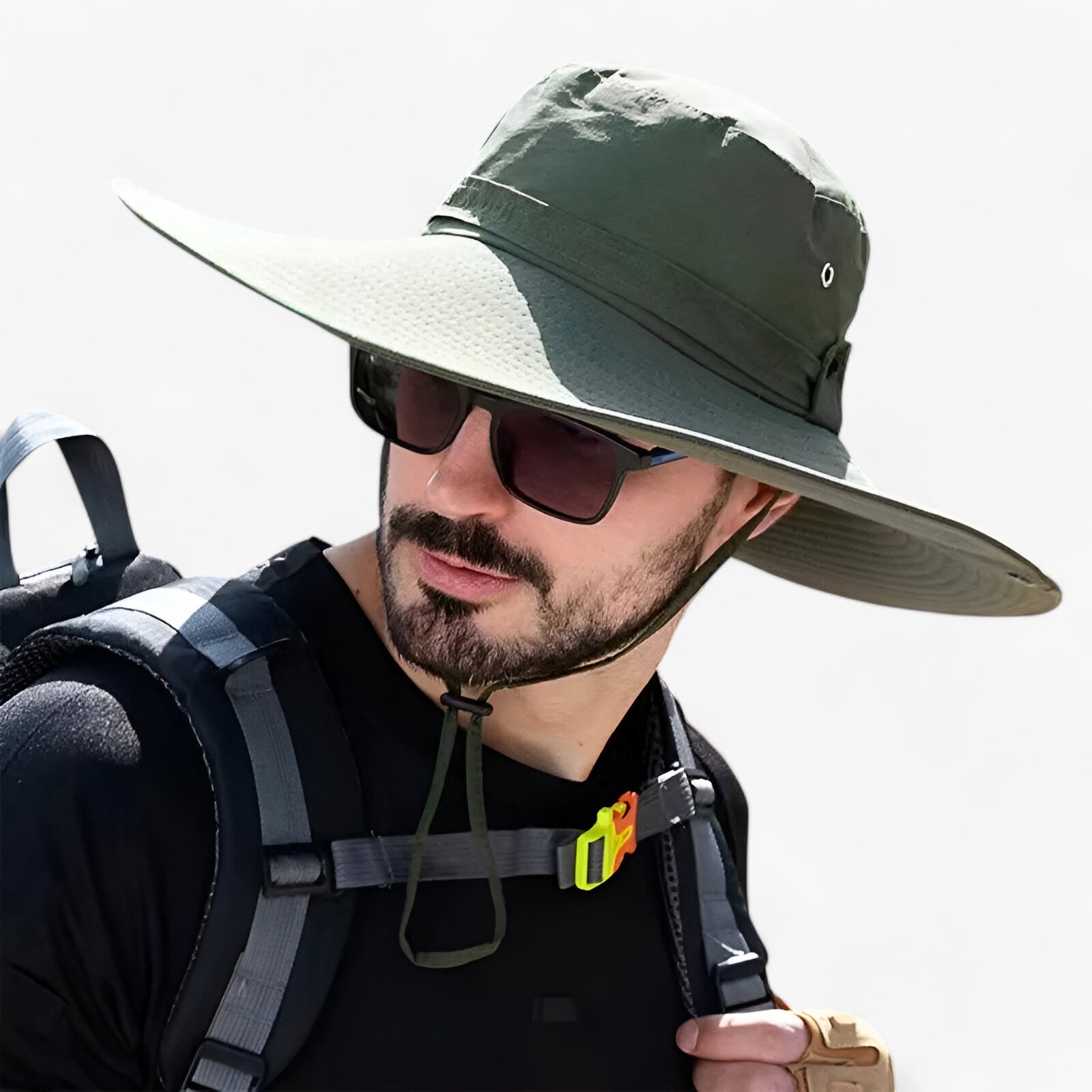 Man wearing an olive green Fitlybuy Zeno UV protection sun hat with wide brim, chin strap, and hiking gear.