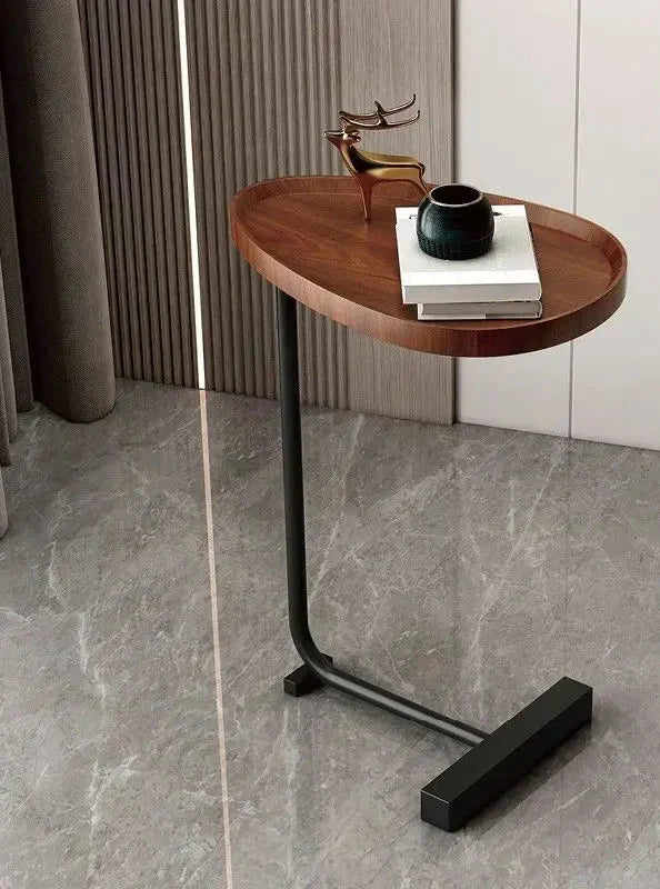 Fitlybuy C-shaped modern side table with an oval wood top and black metal base on a gray marble floor.