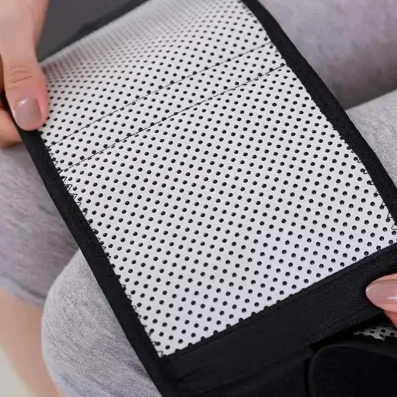 Fitlybuy self-heating white and black lumbar waist bandage with a dotted thermal grid texture held by two hands.