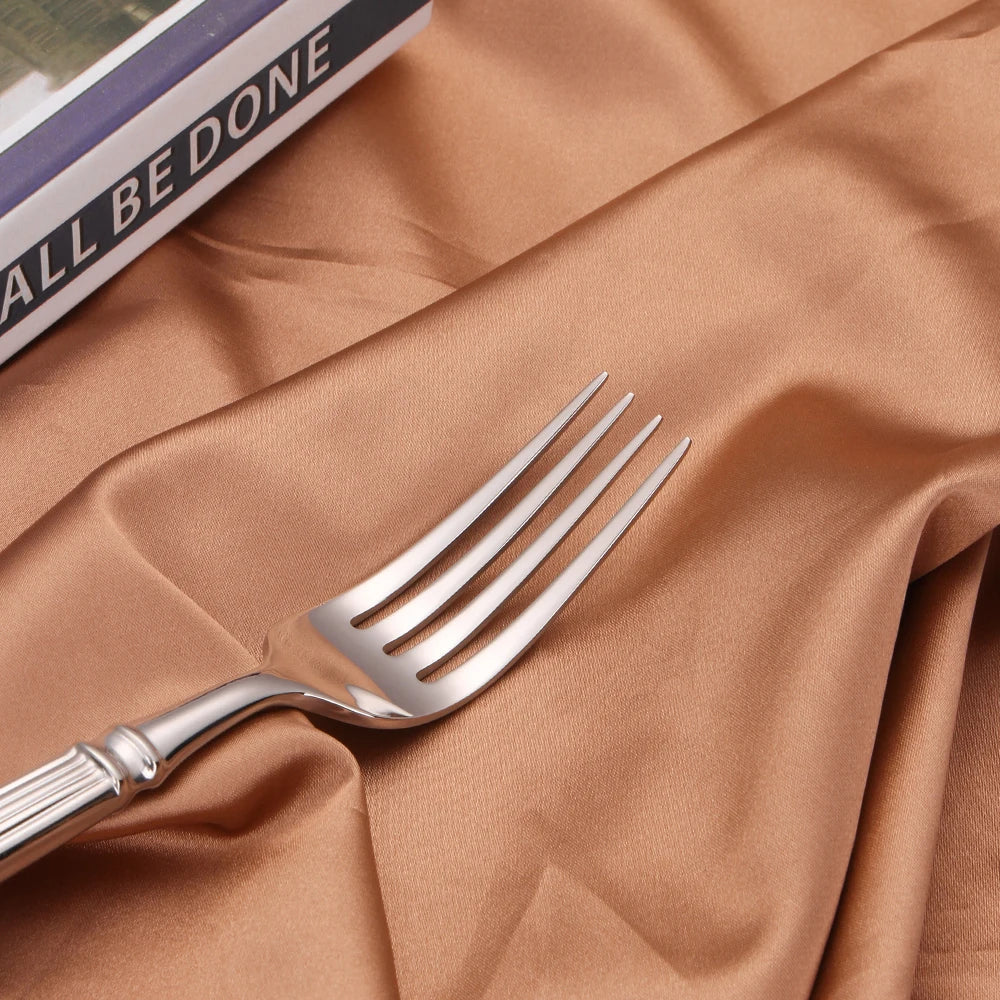 Fitlybuy premium mirror-finish stainless steel fork on elegant, draped gold-toned fabric.