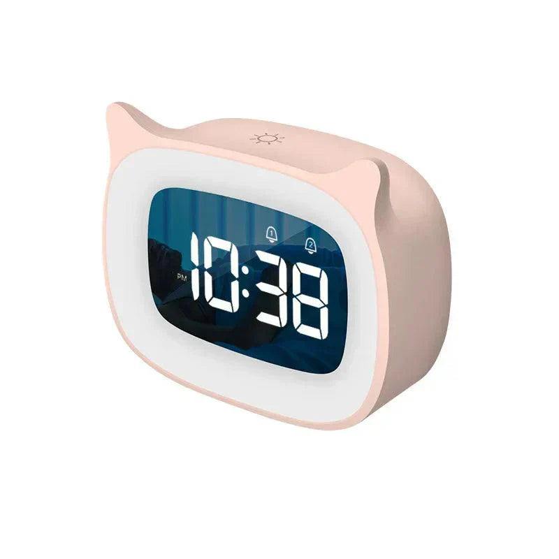 Pink cat-ear shaped LED alarm clock with white digital display showing "10:38 PM" and dual alarm icons.