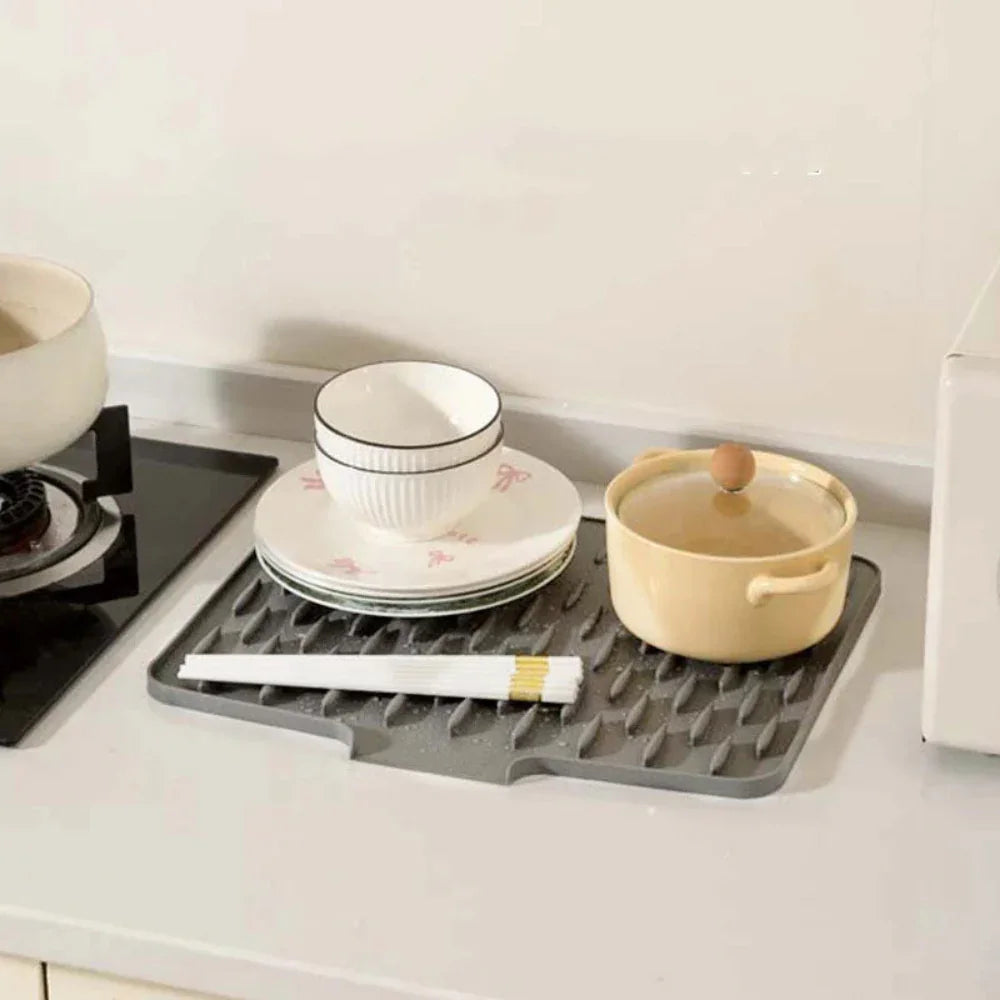 Grey Fitlybuy Silicool silicone drying mat with ribbed, non-slip surface, holding bowls and pots on a kitchen counter.