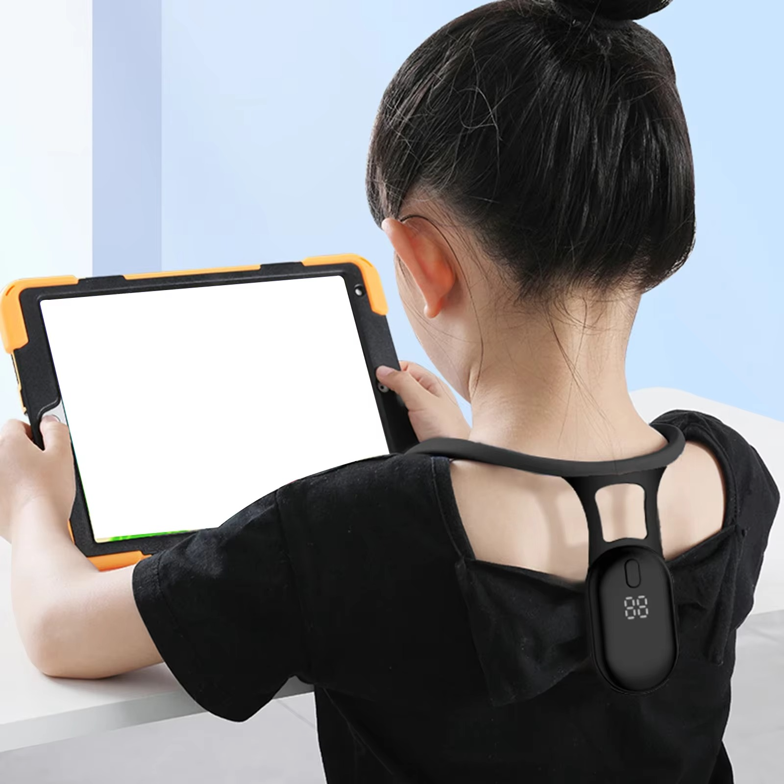 Child wearing a black Fitlybuy SmartSense posture trainer with a digital display while using a tablet.