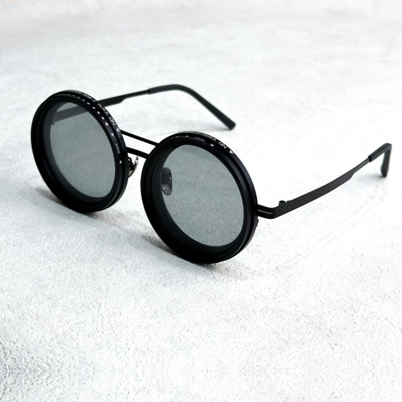 Fitlybuy black metal round polarized sunglasses with adjustable ND light reduction filter dials on a white surface.