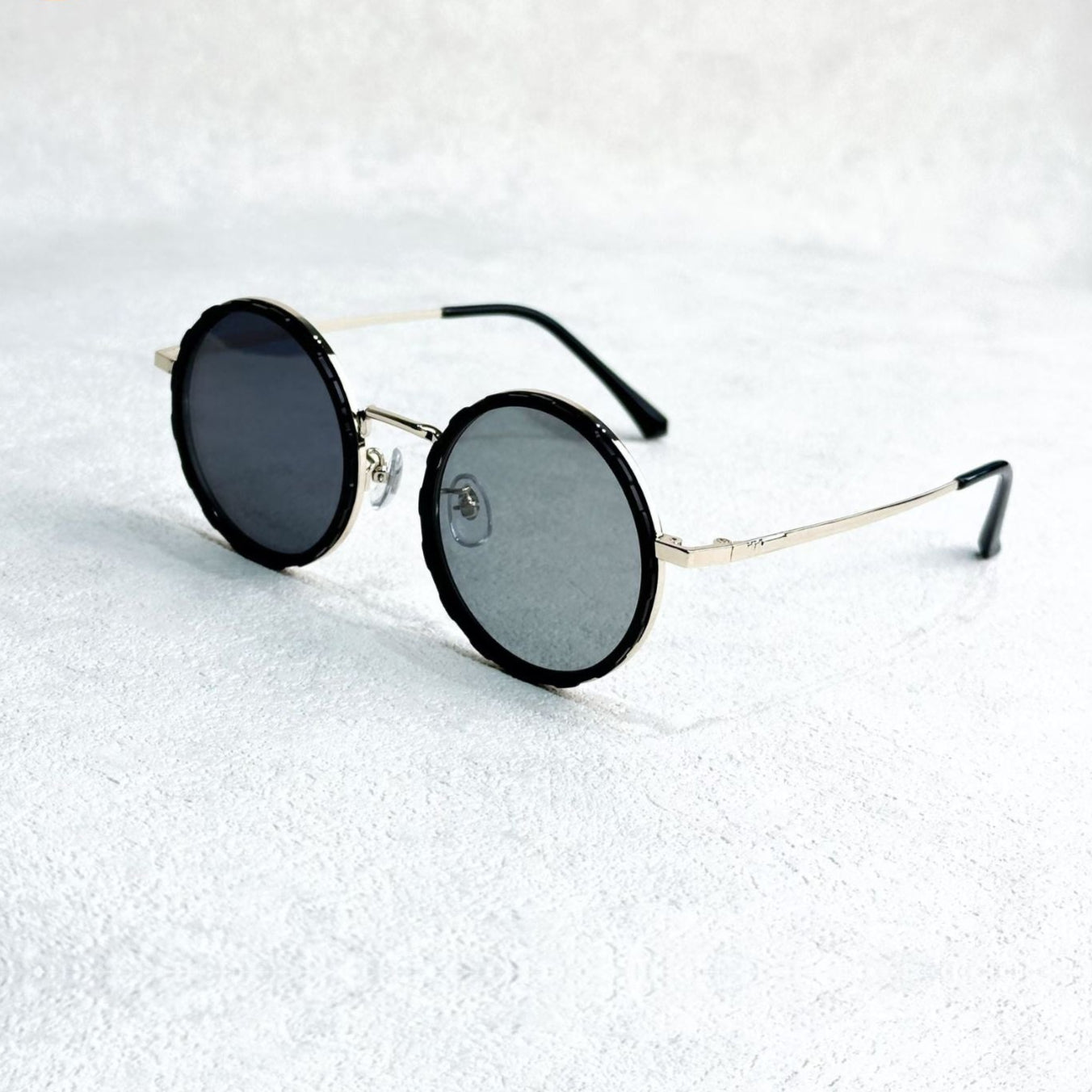 Fitlybuy round polarized sunglasses with gold metal frames and black rims, displayed on a textured white surface.