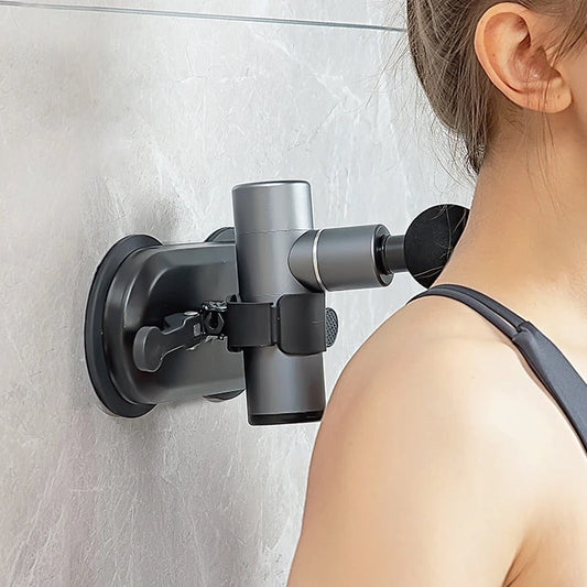 Fitlybuy massage gun mounted on a wall via a black suction cup bracket, massaging a woman’s neck.