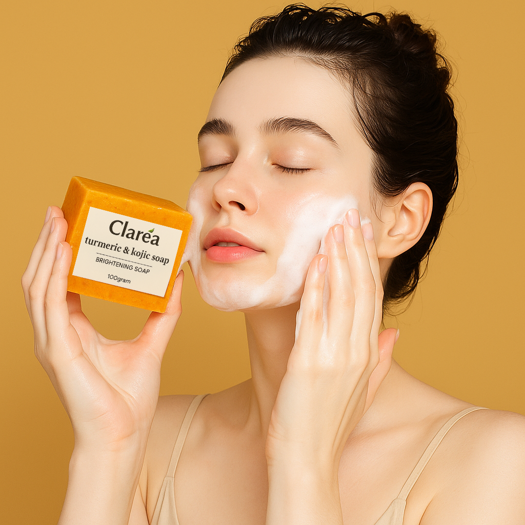 Woman using orange Claréa turmeric and kojic acid brightening soap bar with rich lather on a yellow background.