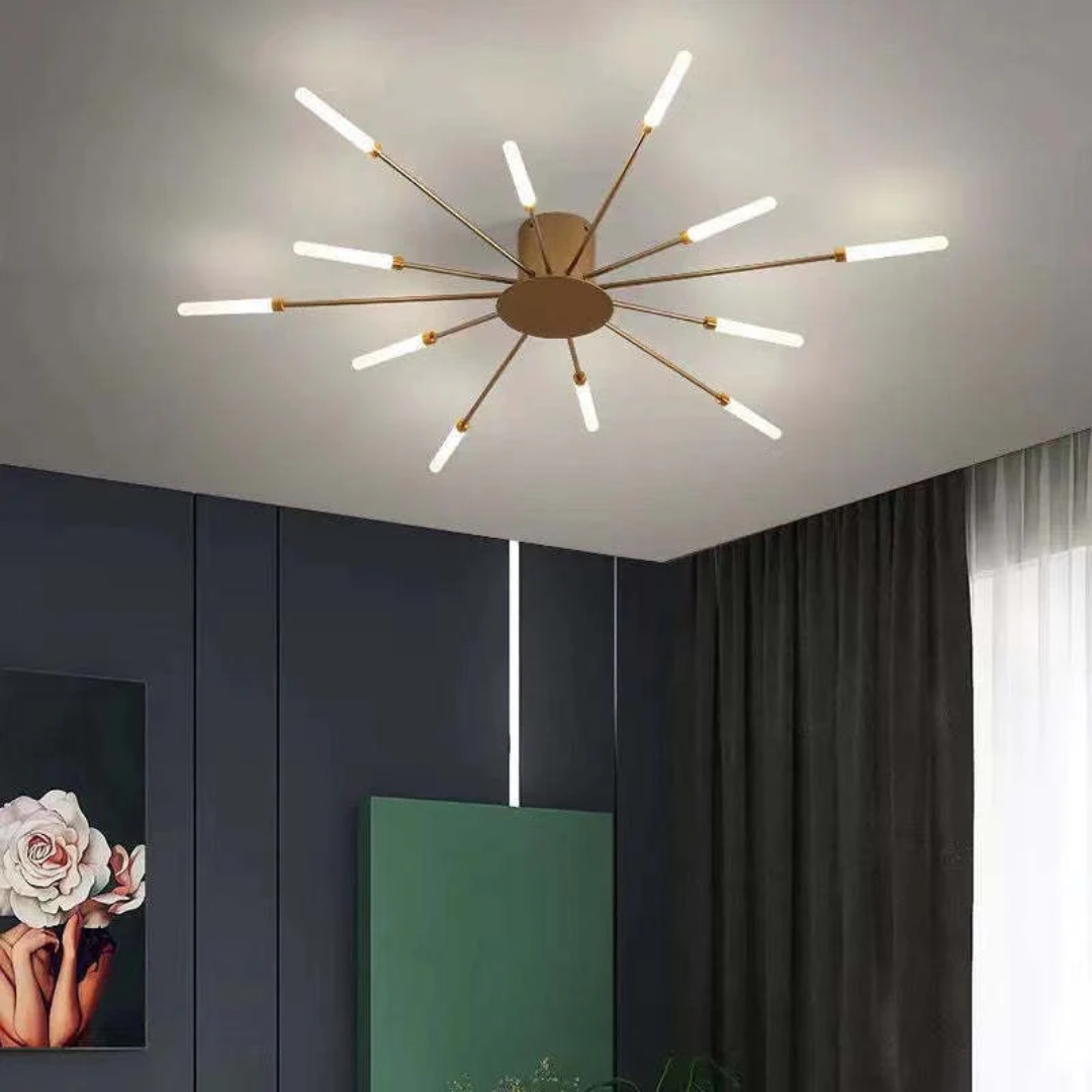 Modern gold sputnik LED ceiling light with 12 glowing arms installed in a contemporary room with dark decor.