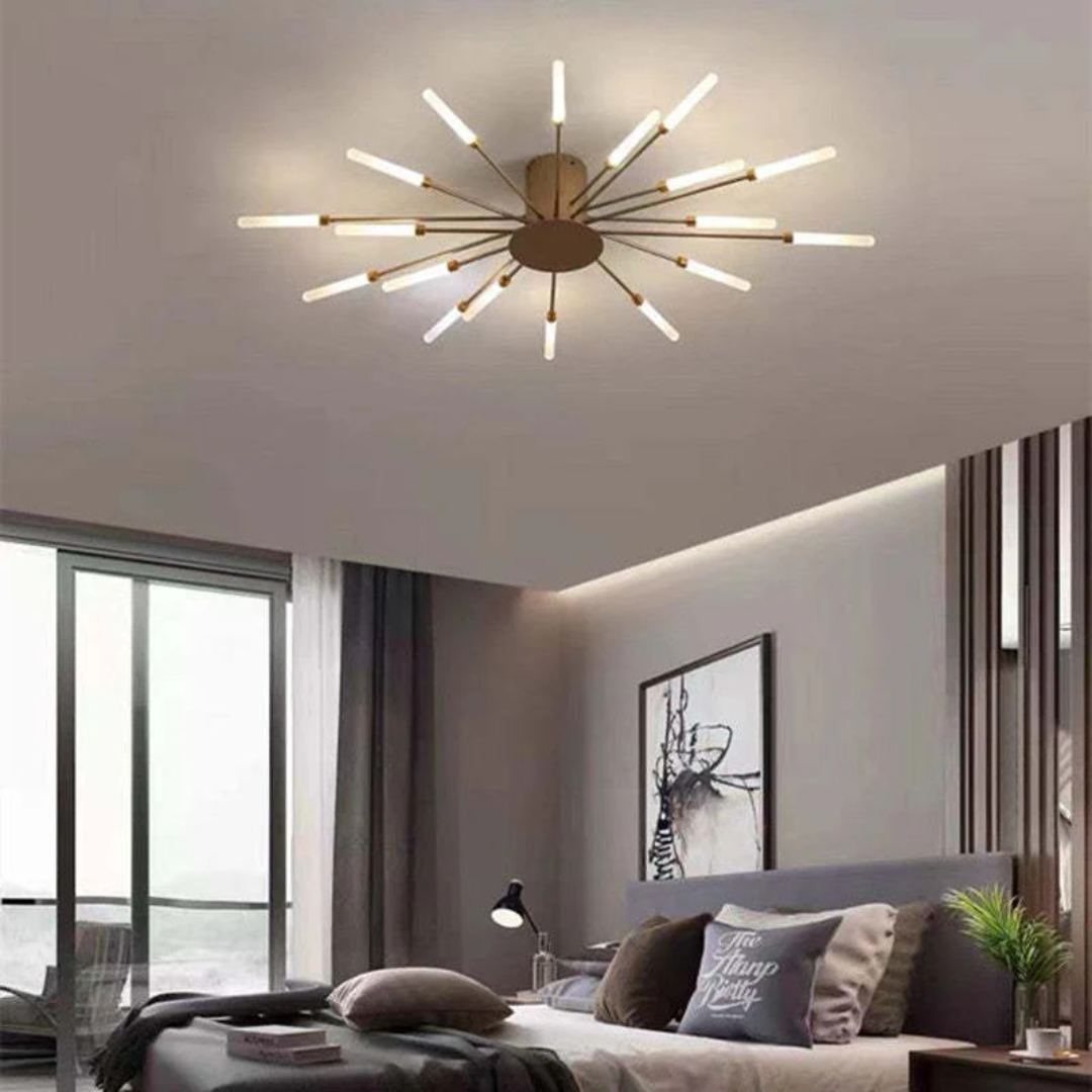 Modern sunburst LED ceiling light in bronze, featuring radiating glowing arms in a contemporary bedroom setting.