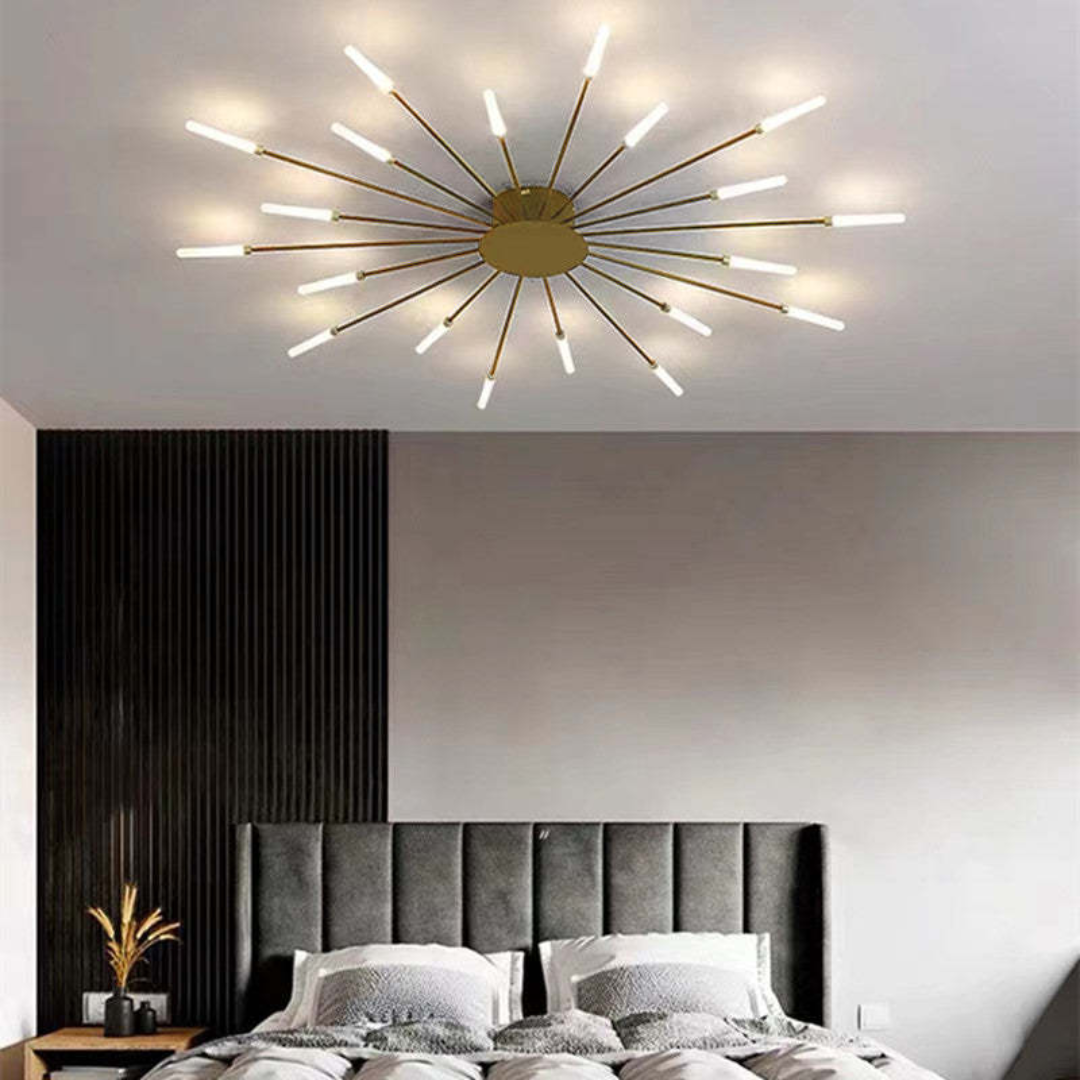 Fitlybuy modern gold starburst LED ceiling light with glowing prong tips, mounted in a contemporary gray bedroom.