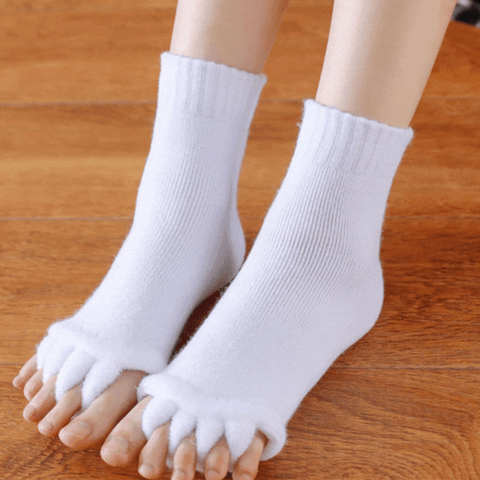 Fitlybuy white toe separator socks with ComfortFlex gel cushioning on feet, worn over wood floor.