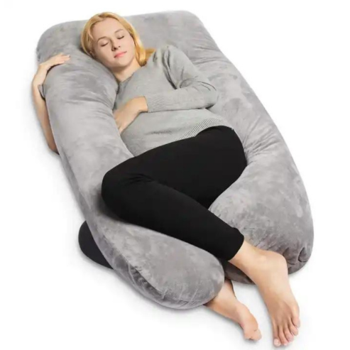 Pregnant woman sleeping on a plush, gray U-shaped Fitlybuy full body pillow for adaptive support.