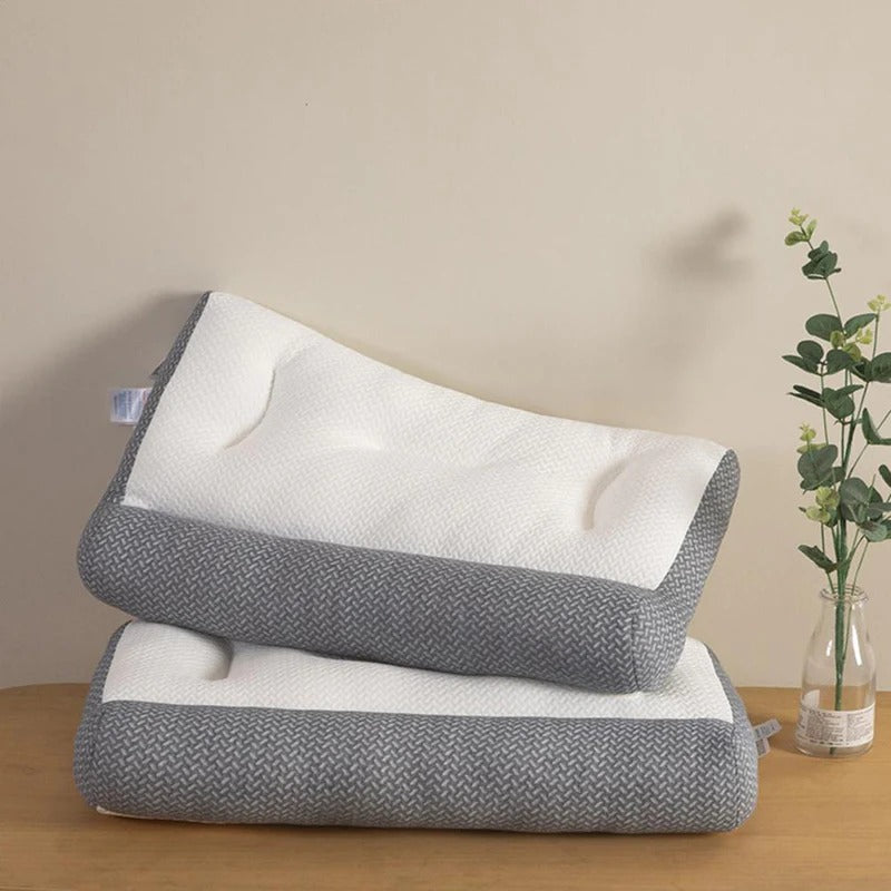 Two Fitlybuy ergonomic pain relief pillows with white quilted tops and textured gray borders on a wooden table.