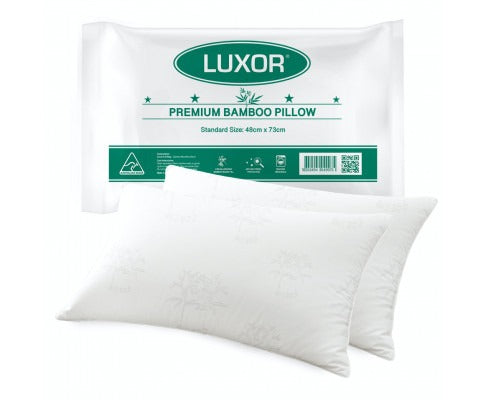 Two white, bamboo-patterned cooling pillows in front of a green and white Luxor premium packaging bag.