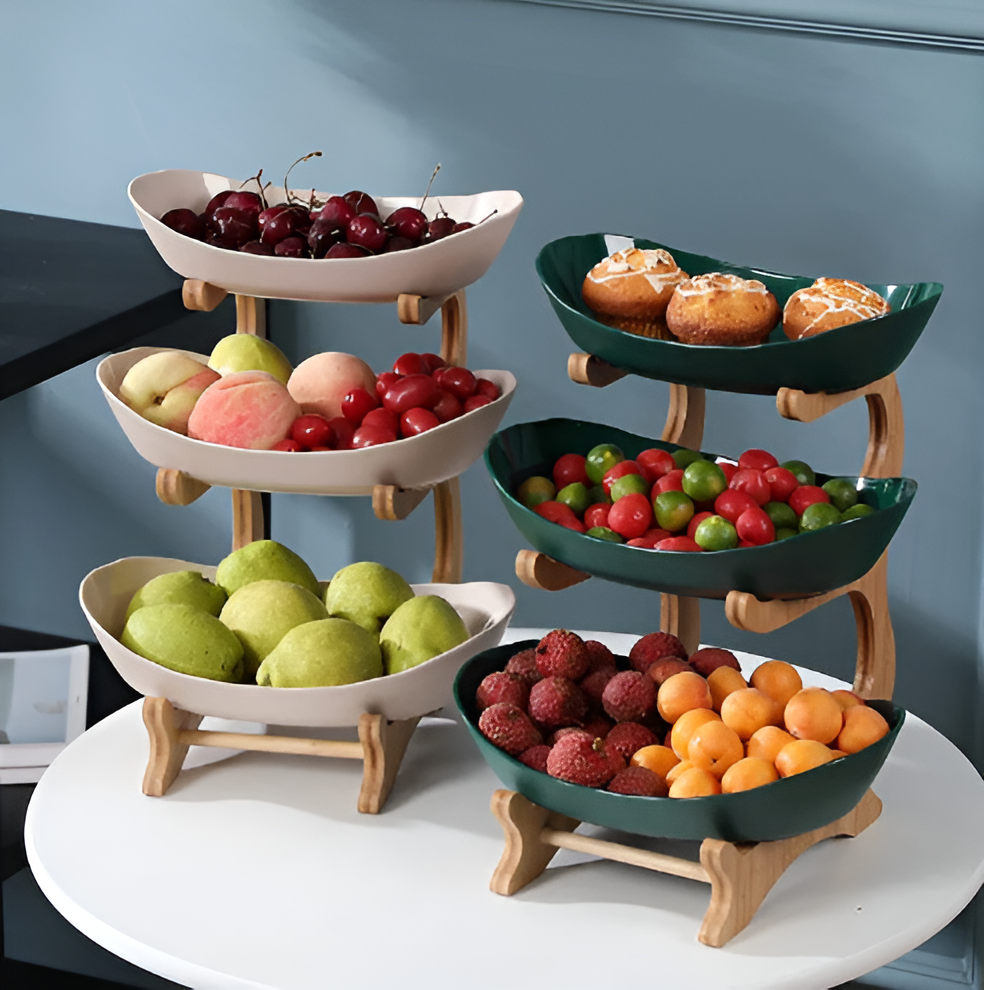 Fitlybuy wooden tiered fruit bowl set with white and dark green oval dishes filled with fresh fruit on a round table.