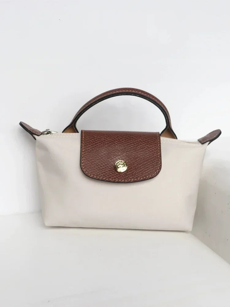 Fitlybuy Calo mini handbag: cream nylon body, brown leather flap with gold snap, top handle, and zippered closure.