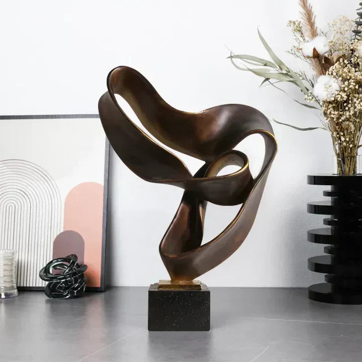 Fitlybuy Vida modern bronze resin ribbon sculpture on a black square base, styled on a table with decor.