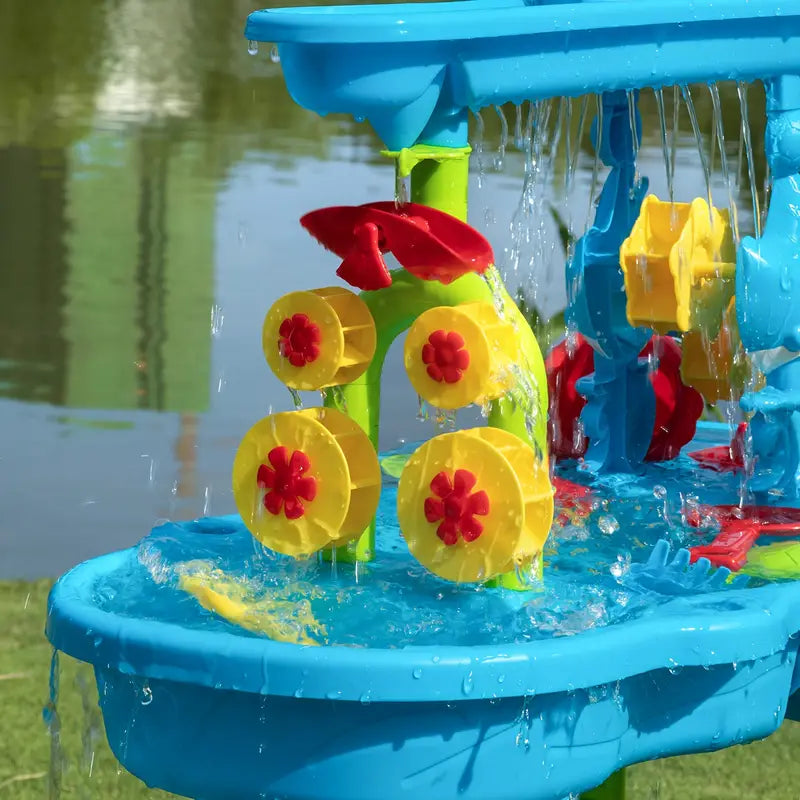 Fitlybuy 3-tier blue sand and water table with yellow-red spinning water wheels, outdoors on grass.